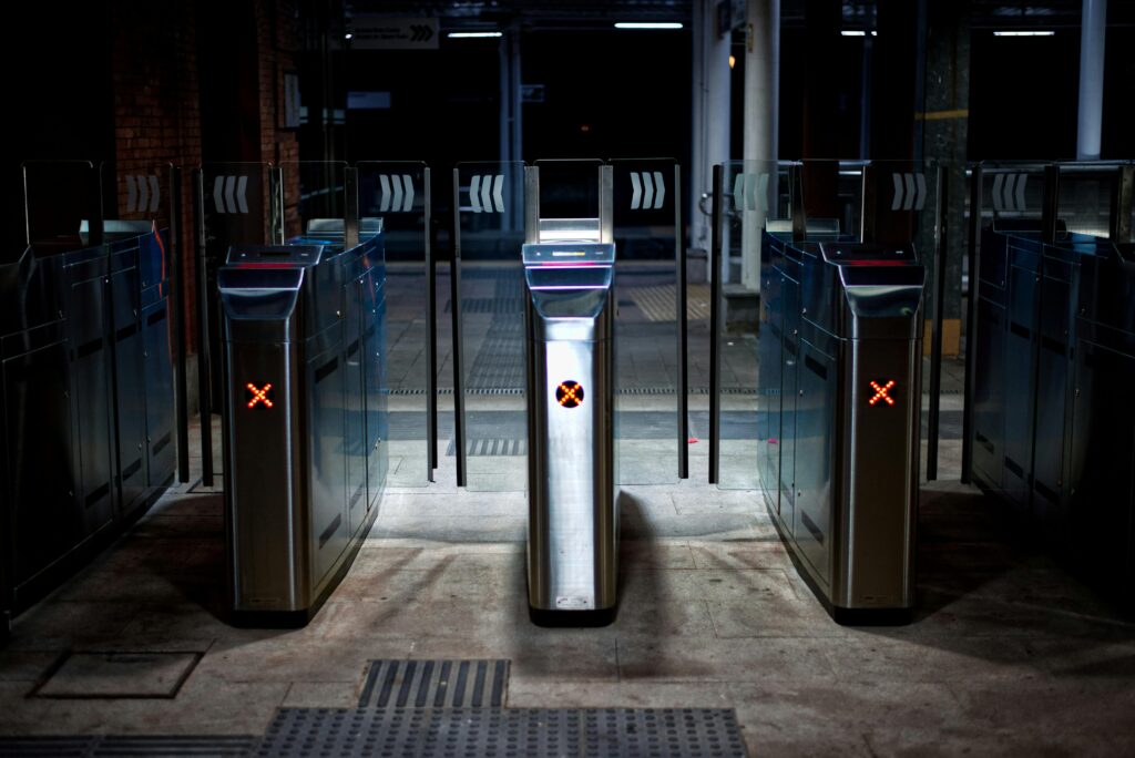 A set of illuminated turnstiles in a subway station at night, emphasizing modern urban travel.